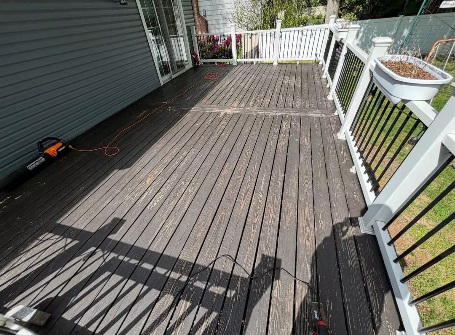 Weathered deck surface before restoration, with visible wear across the boards.