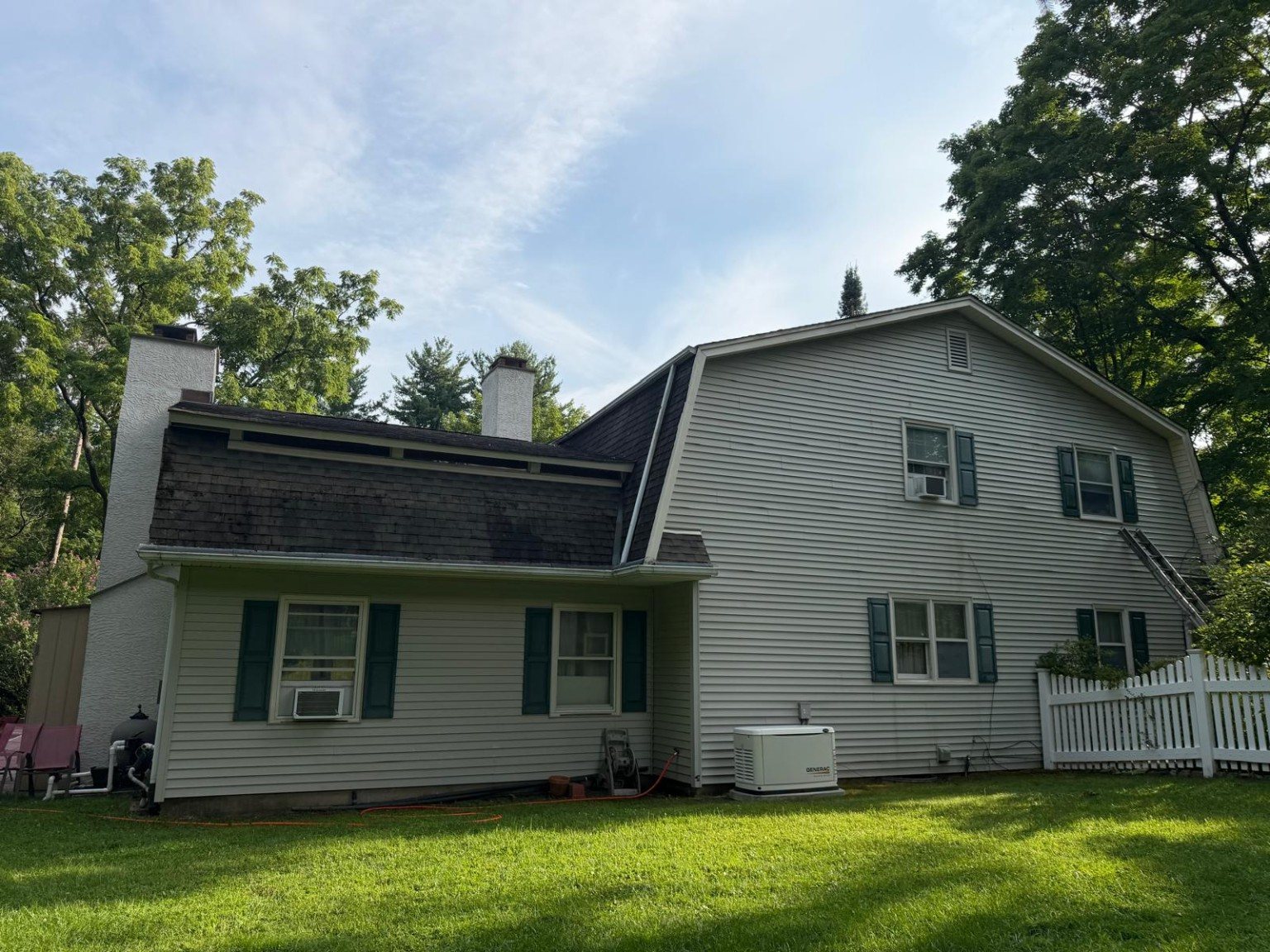 Rear exterior of the home after cleaning with a brighter and more uniform siding appearance.