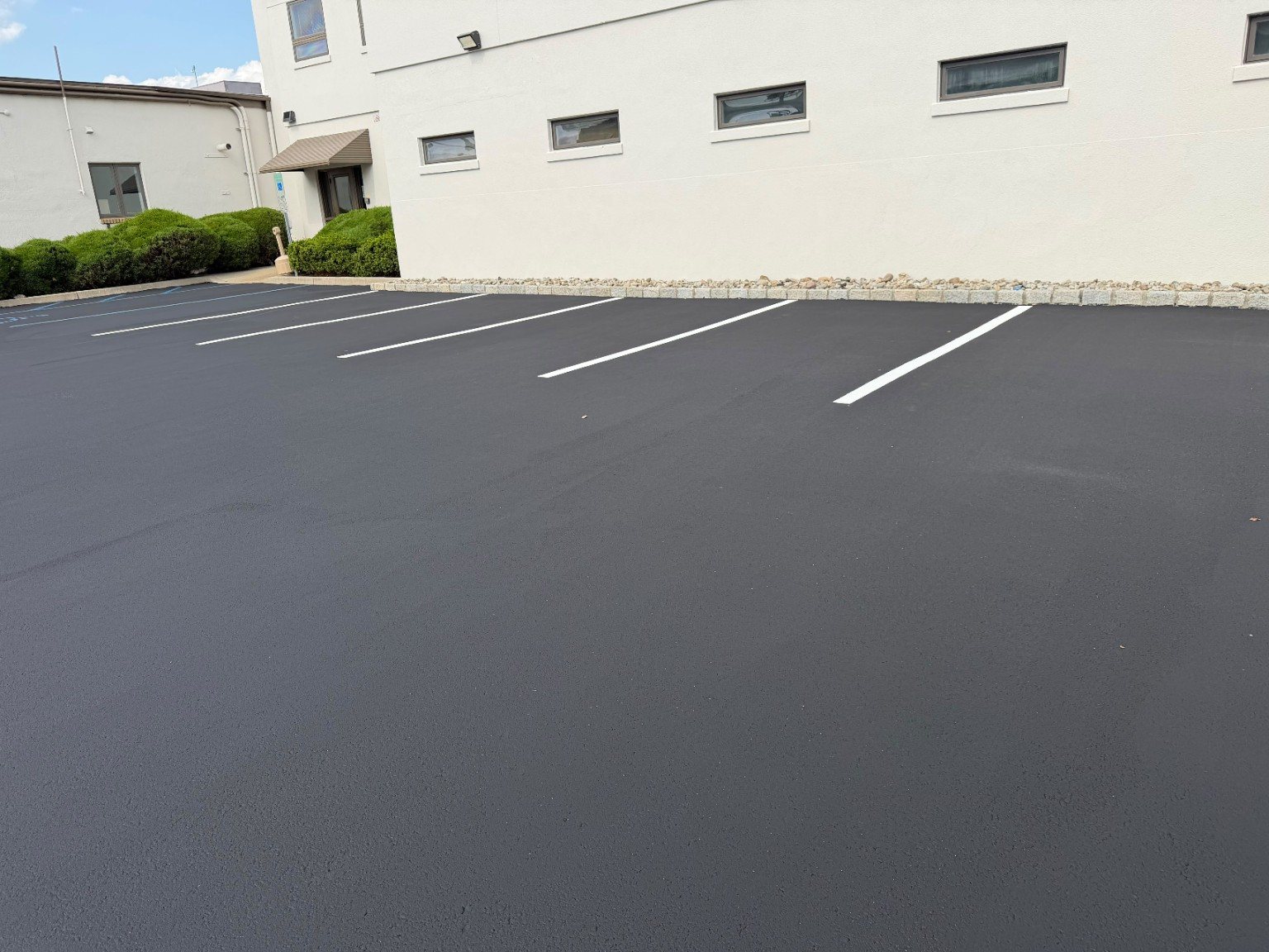 Finished commercial parking area with dark uniform pavement and bright white parking lines.