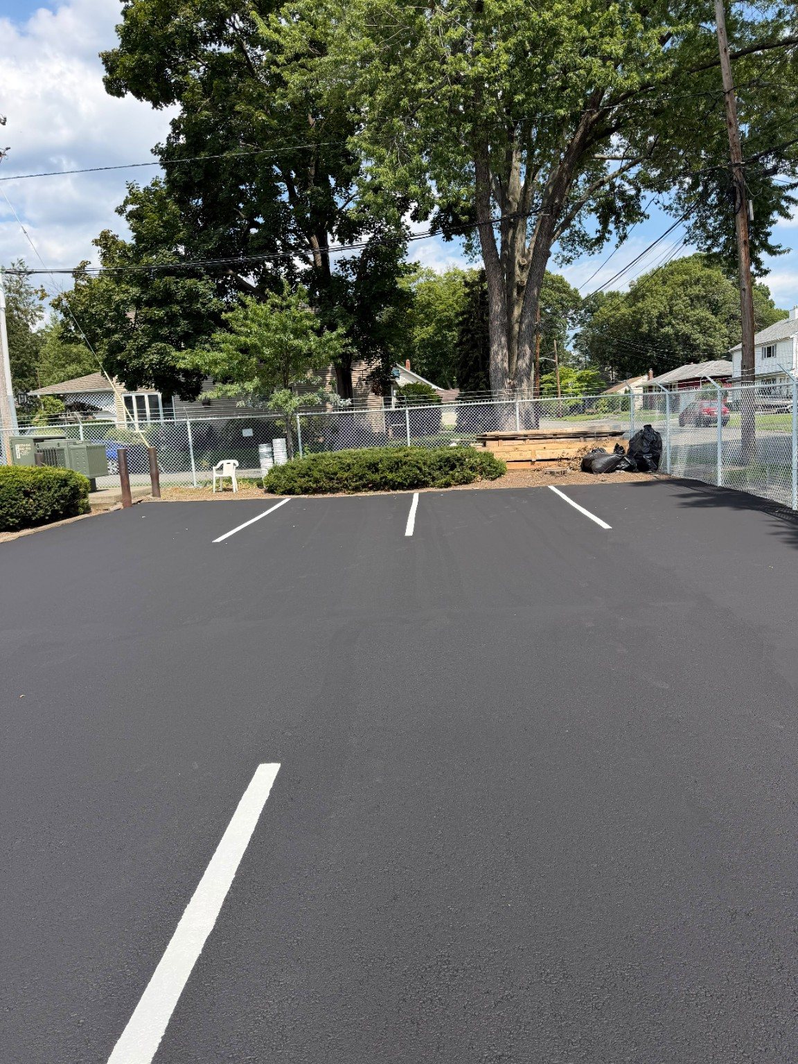 Finished commercial parking lot with dark pavement and bright white stall markings.